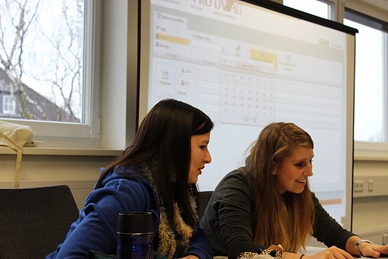 Studentinnen vor Leinwand